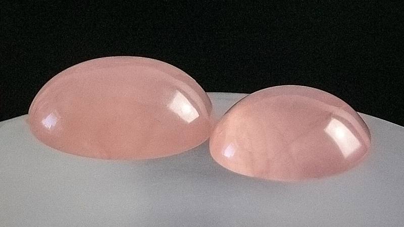 Two polished rose quartz cabochons
